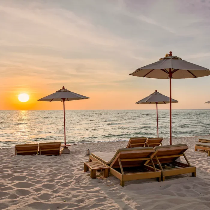 Beach loungers and umbrellas at sunset at Grand Cay